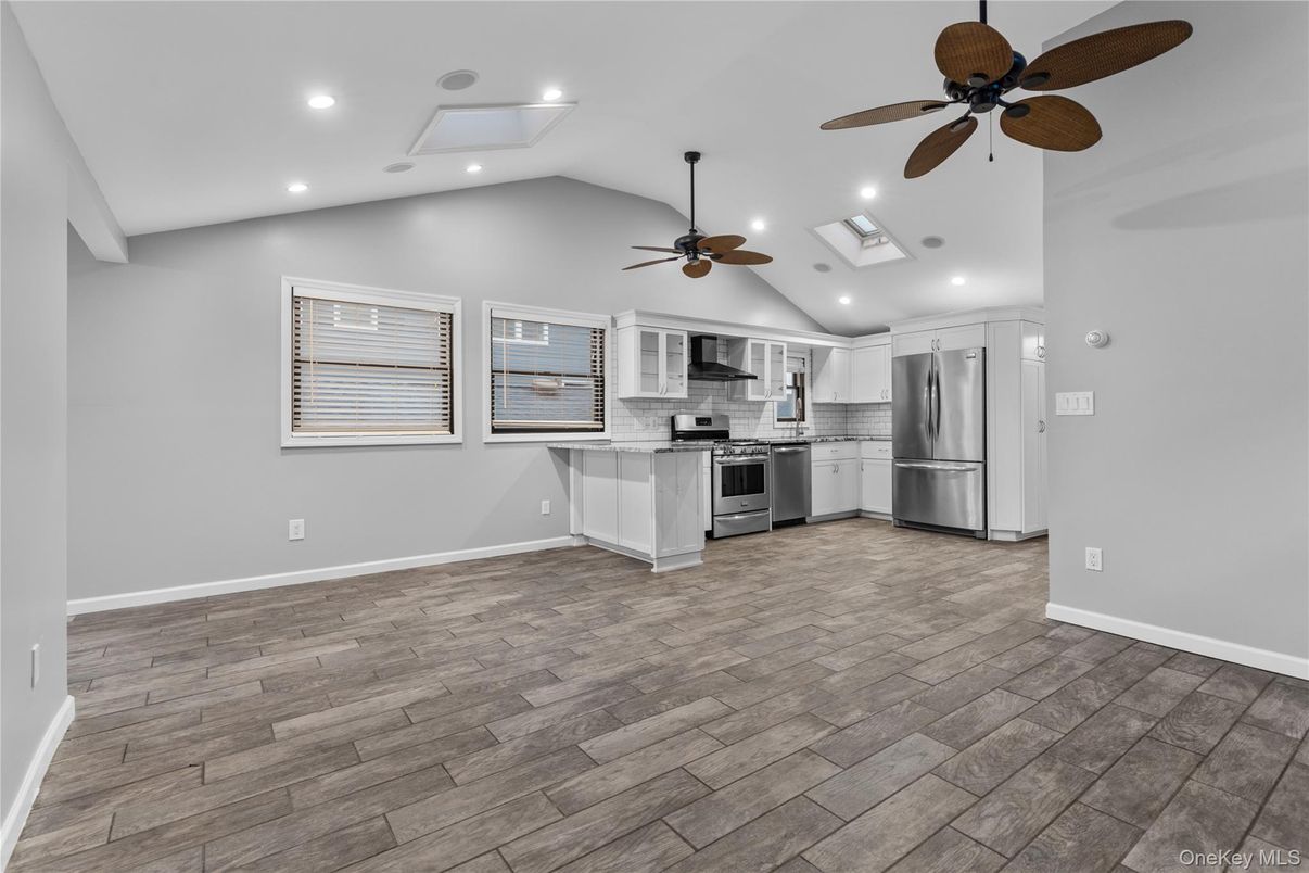 Empty room, Interior, Kitchen, Recessed Lighting, Stainless Steel Appliances, Wood Texture Flooring
