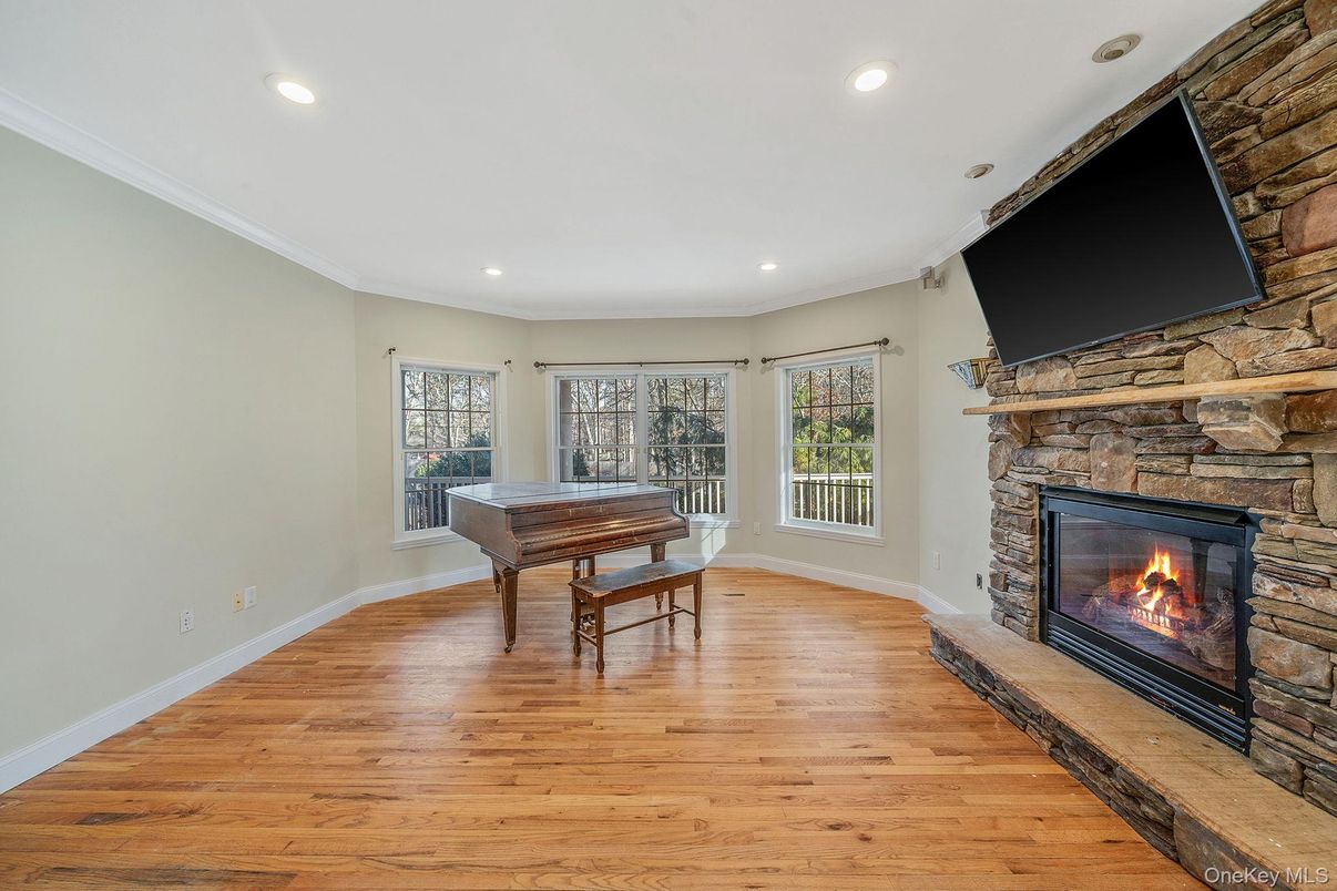 Fireplace, Game Room, Interior, Piano, Recessed Lighting, Stone Walls, Wood Texture Flooring