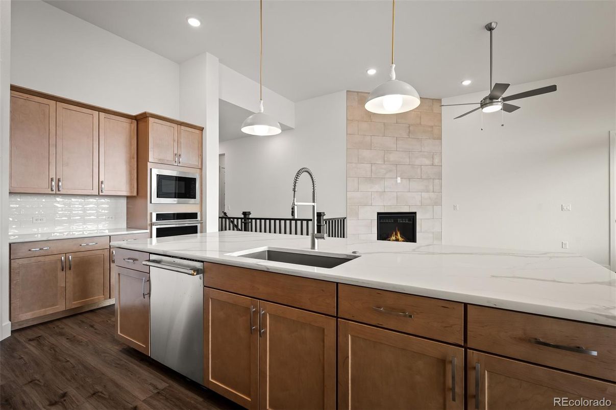 Fireplace, Interior, Kitchen, Pendant Lights, Recessed Lighting, Stainless Steel Appliances, Stone Walls, Wood Texture Flooring