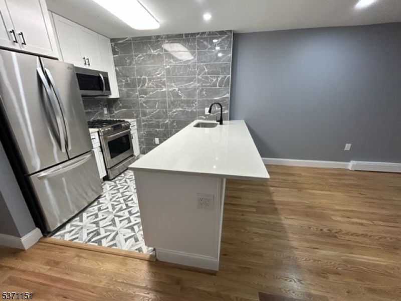 Interior, Kitchen, Marble Walls, Recessed Lighting, Stainless Steel Appliances, Wood Texture Flooring