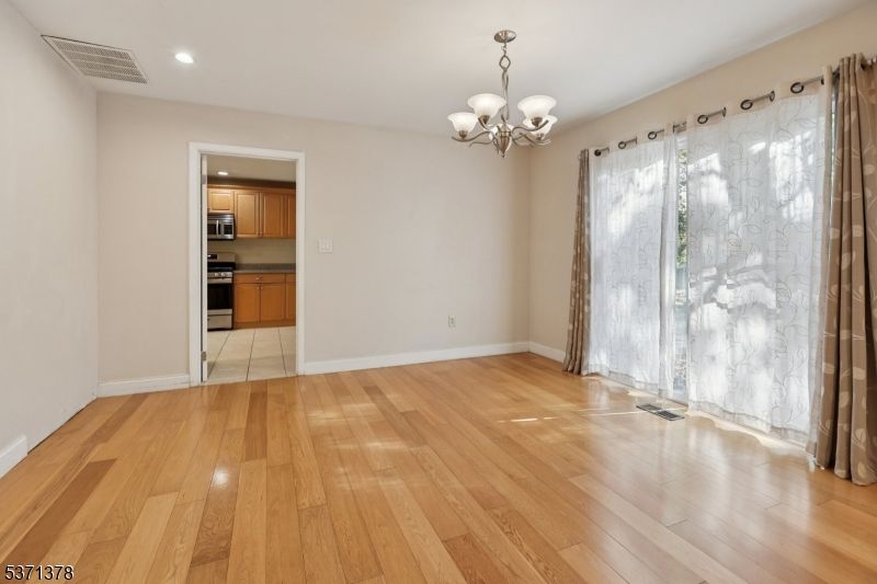 Chandelier, Empty room, Interior, Kitchen, Recessed Lighting, Stainless Steel Appliances, Wood Texture Flooring