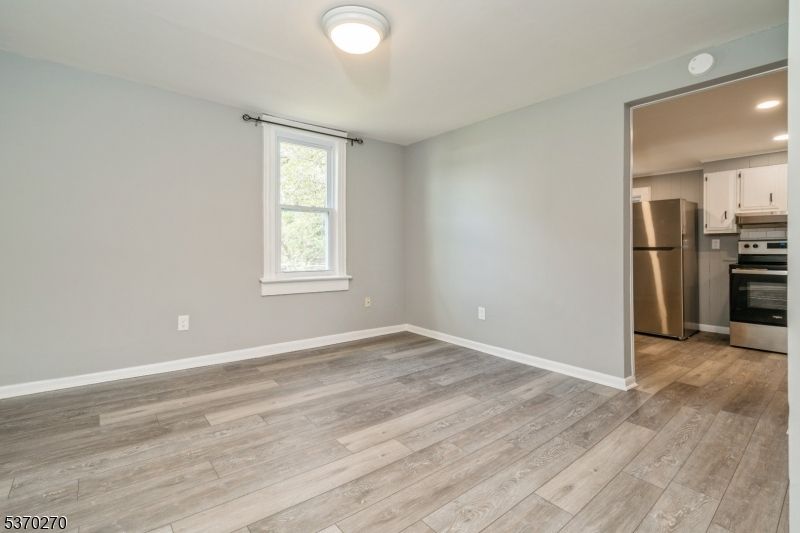 Empty room, Interior, Kitchen, Recessed Lighting, Stainless Steel Appliances, Wood Texture Flooring