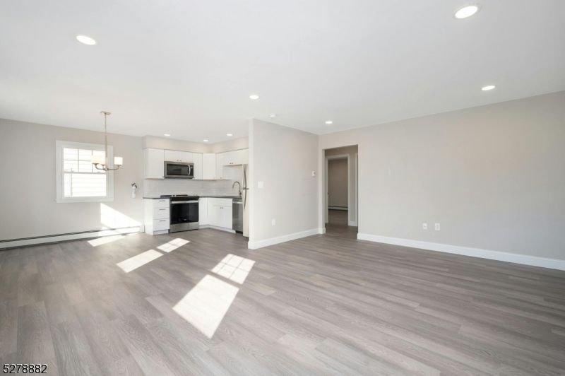 Empty room, Interior, Kitchen, Pendant Lights, Recessed Lighting, Stainless Steel Appliances, Wood Texture Flooring