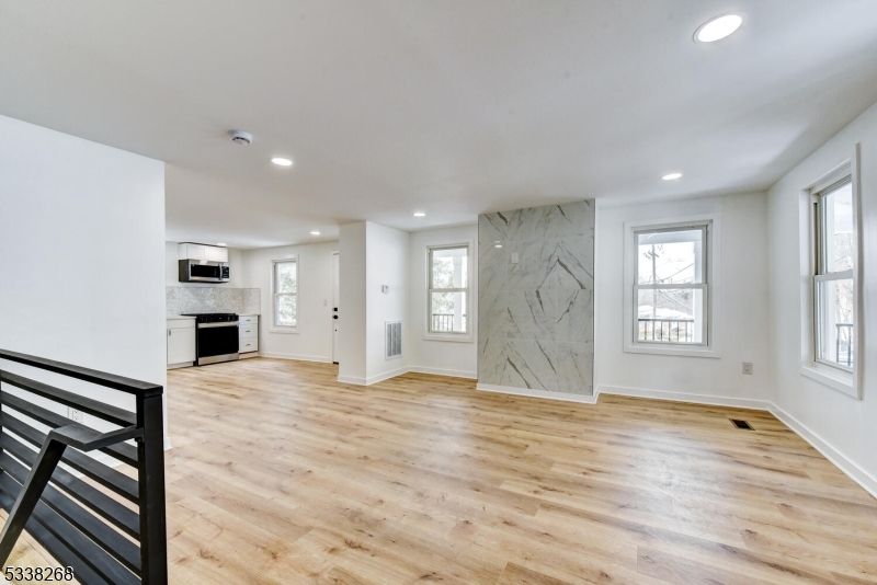 Empty room, Interior, Kitchen, Marble Walls, Recessed Lighting, Stainless Steel Appliances, Wood Texture Flooring