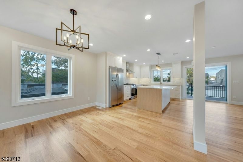 Empty room, Interior, Kitchen, Pendant Lights, Recessed Lighting, Stainless Steel Appliances, Wood Texture Flooring