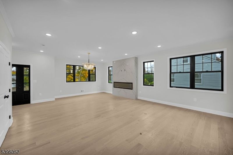 Chandelier, Empty room, Fireplace, Interior, Marble Walls, Recessed Lighting, Wood Texture Flooring
