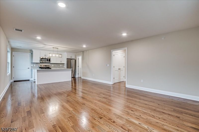 Empty room, Interior, Kitchen, Pendant Lights, Recessed Lighting, Stainless Steel Appliances, Wood Texture Flooring
