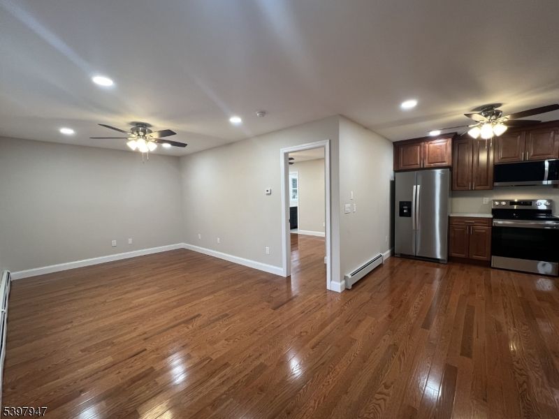 Empty room, Interior, Kitchen, Recessed Lighting, Stainless Steel Appliances, Wood Texture Flooring
