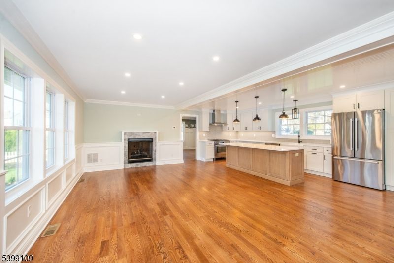 Empty room, Fireplace, Interior, Kitchen, Pendant Lights, Recessed Lighting, Stainless Steel Appliances, Wood Texture Flooring