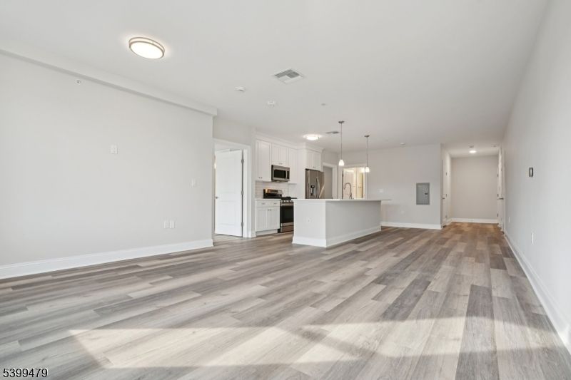 Empty room, Interior, Kitchen, Pendant Lights, Recessed Lighting, Stainless Steel Appliances, Wood Texture Flooring
