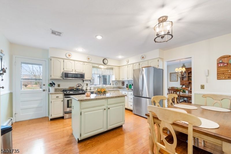 Chandelier, Dining room, Interior, Kitchen, Recessed Lighting, Stainless Steel Appliances, Wood Texture Flooring