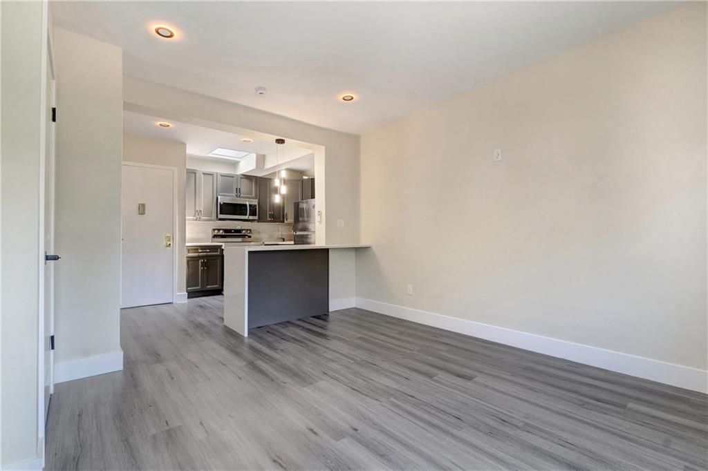 Empty room, Interior, Kitchen, Recessed Lighting, Stainless Steel Appliances, Wood Texture Flooring