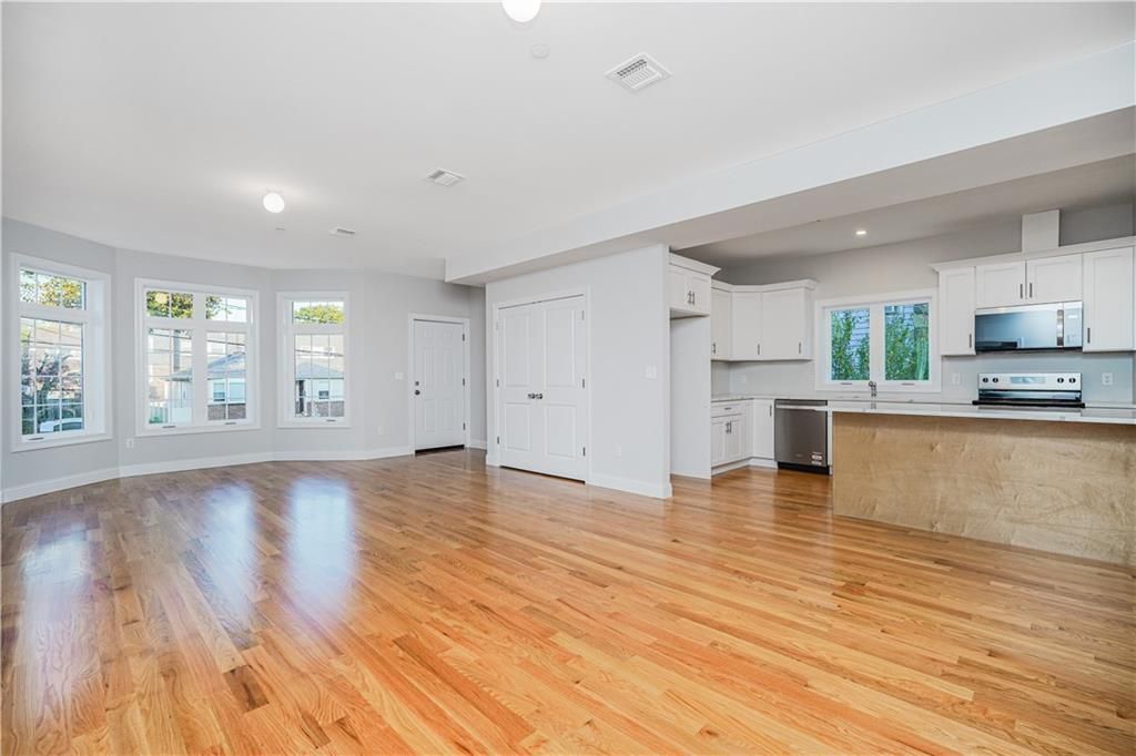 Empty room, Interior, Kitchen, Recessed Lighting, Stainless Steel Appliances, Wood Texture Flooring