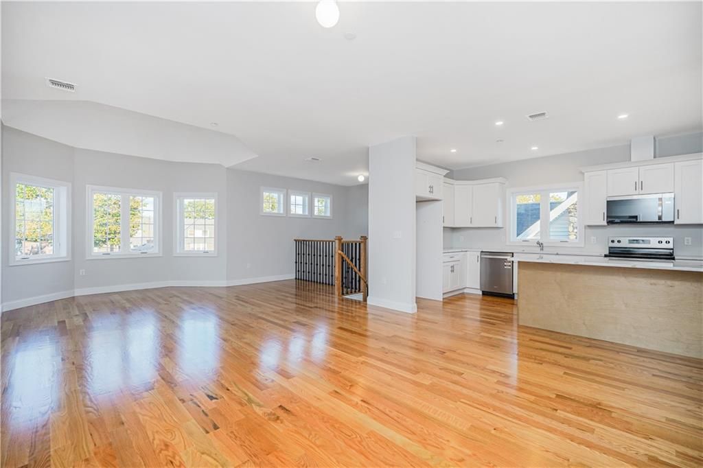 Empty room, Interior, Kitchen, Recessed Lighting, Stainless Steel Appliances, Wood Texture Flooring