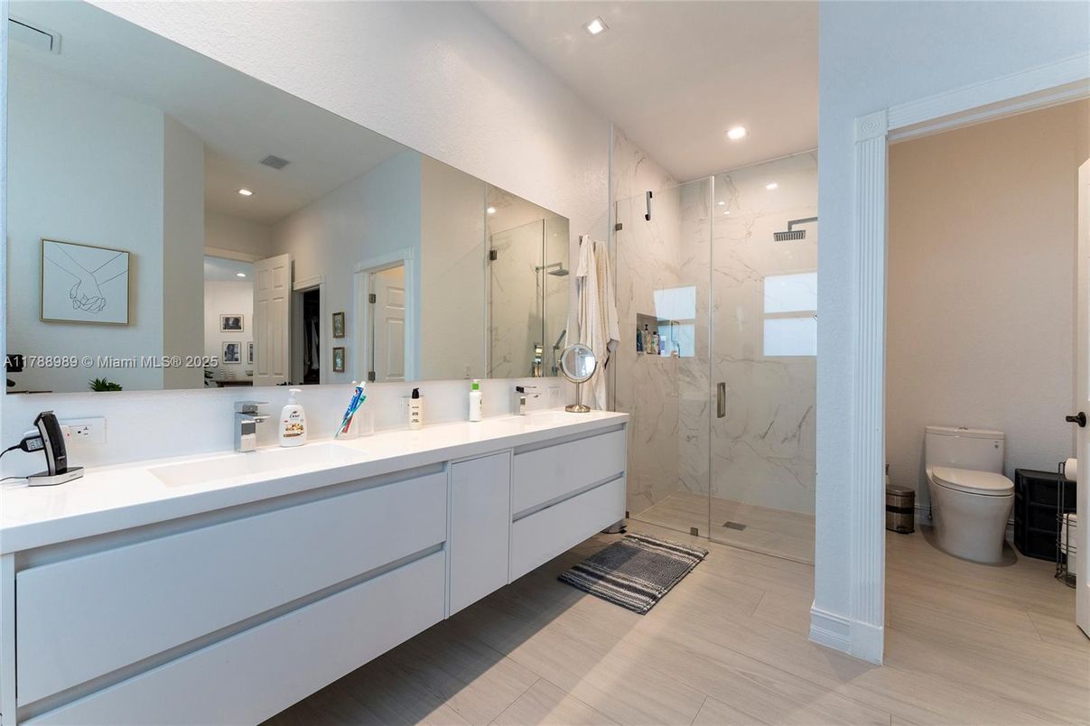 Bathroom, Dual Sink Vanities, Glass Shower, Interior, Marble Walls, Recessed Lighting, Wood Texture Flooring