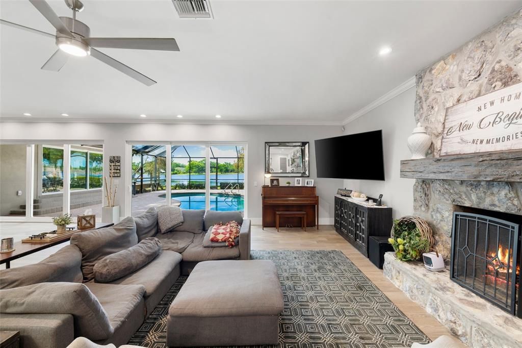 Fireplace, Interior, Living room, Piano, Recessed Lighting, Stone Walls, Water, Wood Texture Flooring