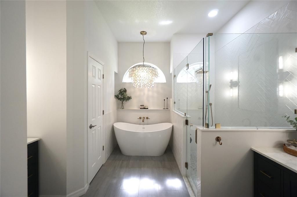 Bathroom, Chandelier, Free Standing Baths, Glass Shower, Interior, Marble Walls, Recessed Lighting, Wood Texture Flooring