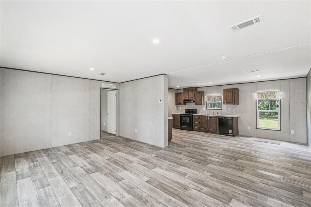 Empty room, Fireplace, Interior, Kitchen, Recessed Lighting, Stainless Steel Appliances, Wood Texture Flooring