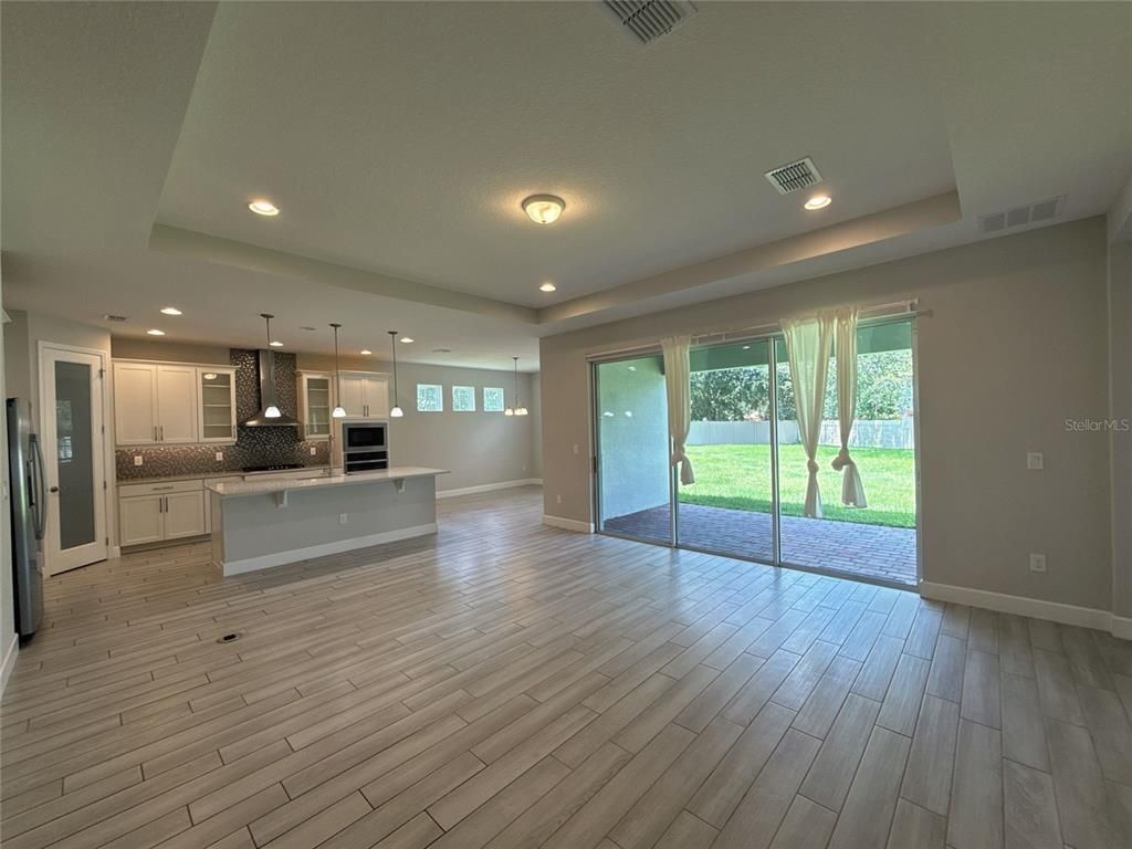Empty room, Interior, Kitchen, Pendant Lights, Recessed Lighting, Stainless Steel Appliances, Wood Texture Flooring
