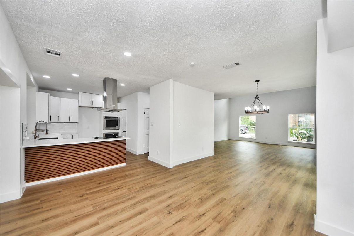 Chandelier, Empty room, Interior, Kitchen, Pendant Lights, Recessed Lighting, Stainless Steel Appliances, Wood Texture Flooring